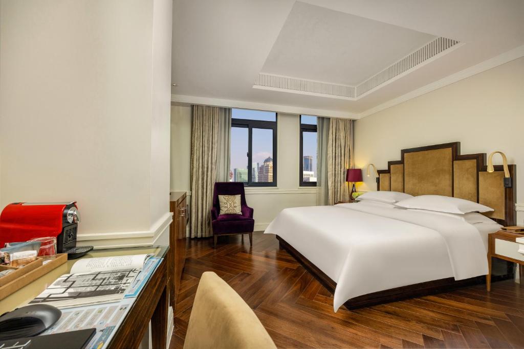 上海市にあるJinjiang Metropolo Hotel Classiq,Shanghai Bund Circleのベッド、デスク、コンピュータが備わるホテルルームです。