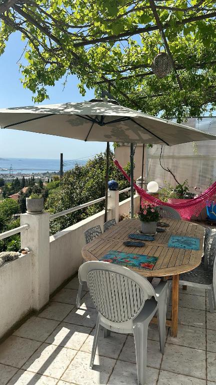 a wooden table with an umbrella on a patio at FLC-Sea View-Jacuzzi-3 Bedrooms-8p-Parking for 2 cars in Marseille
