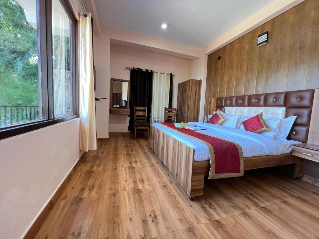 a bedroom with a large bed and a large window at Hotel Canadian forest view in Dalhousie
