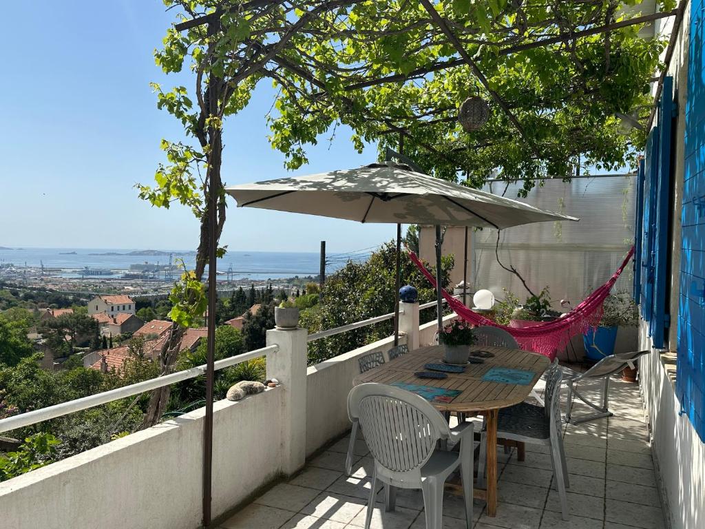 a patio with a table and an umbrella at FLC-Sea View-Jacuzzi-3 Bedrooms-8p-Parking for 2 cars in Marseille