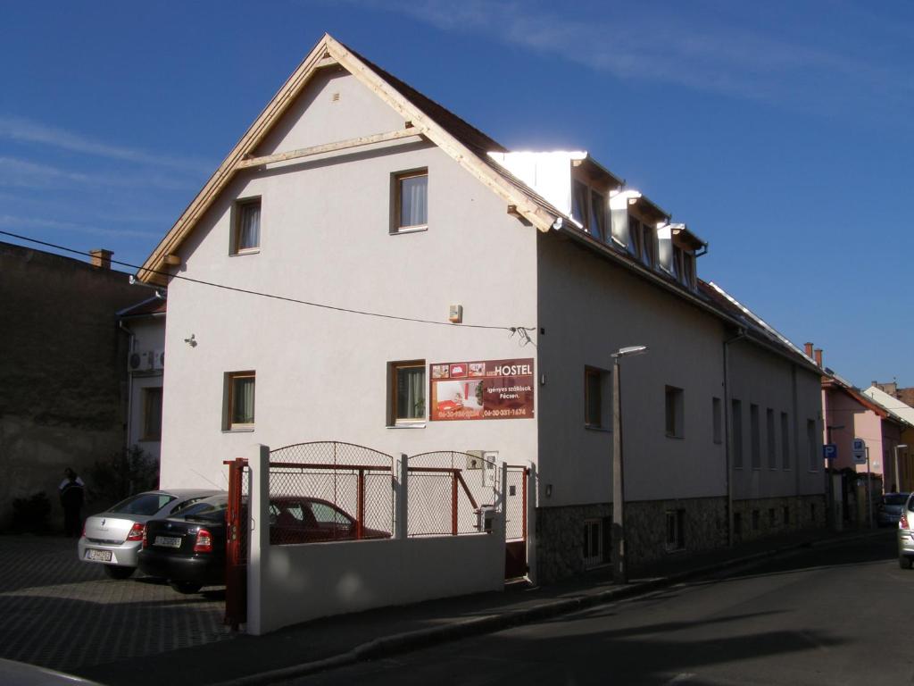 a white house with a car parked in front of it at Liszt Apartman in Pécs