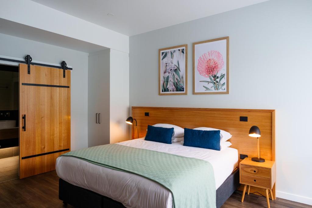 1 dormitorio con 1 cama grande con almohadas azules en Aberdeen Lane, en Woodside