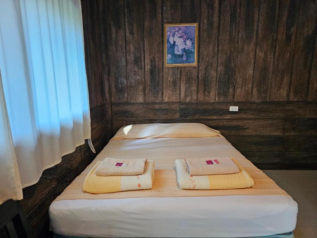 um quarto com 2 camas e toalhas em Fire Fly Chalet em Ban Chom Phon