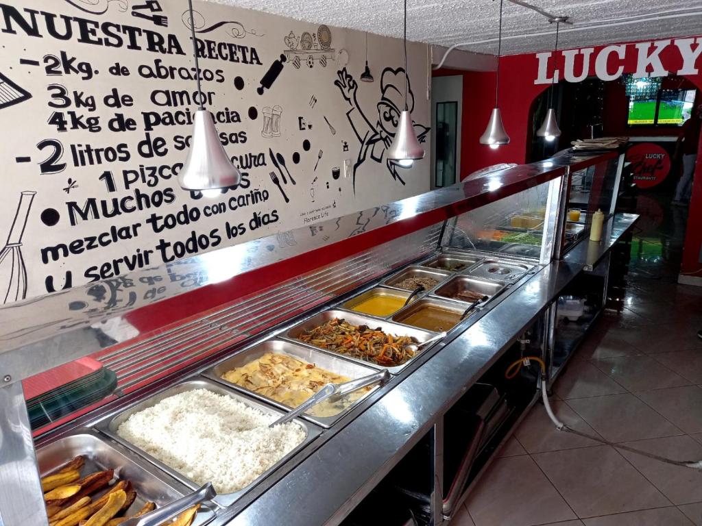 uma linha de buffet com muitos tipos diferentes de alimentos em Hotel boutique San Pablo em Medellín