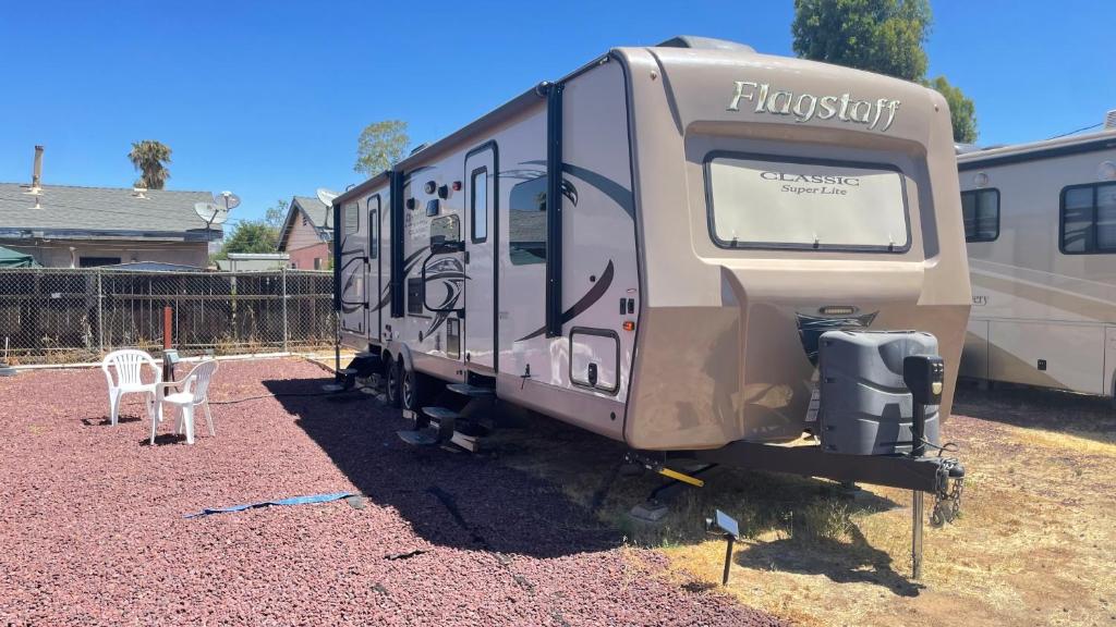 an rv parked in a yard next to a fence at Camper Rv1 with private entrance and free parking in Moreno Valley