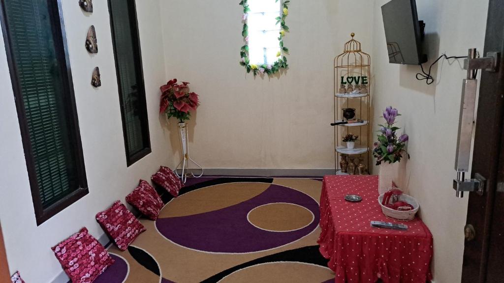 una sala de estar con una mesa roja y una habitación con alfombra en Vallery homestay en Geruntang