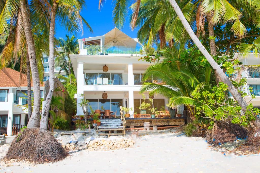 um hotel na praia com palmeiras em Mayumi Beach Villa em Boracay