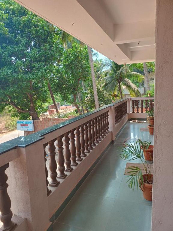 a balcony of a house with potted plants and trees at Ashirwad Residency in Agonda