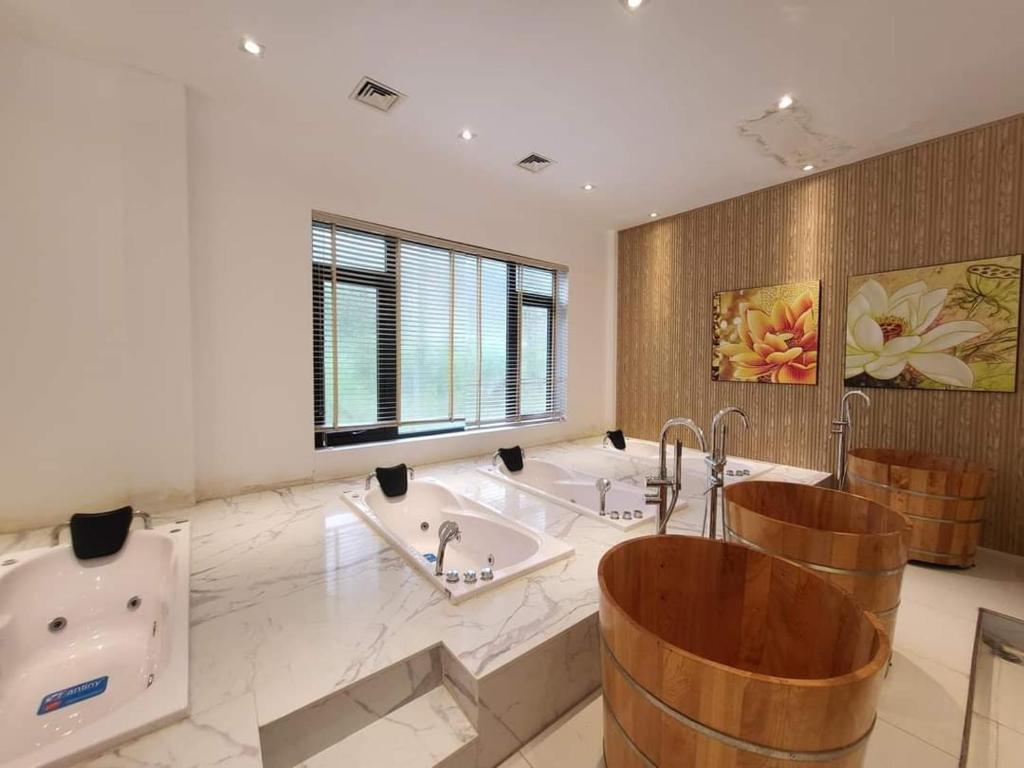 uma casa de banho com 2 banheiras e 2 lavatórios em Ivory Villa & Resort em Hòa Bình