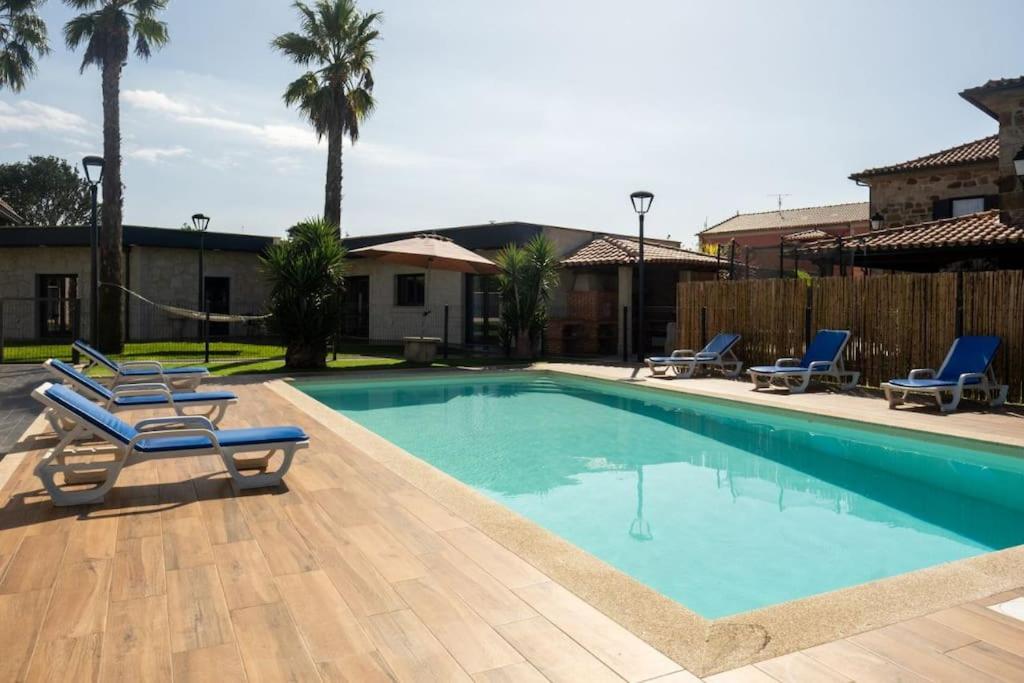 einen Pool mit zwei Liegestühlen neben in der Unterkunft Logement avec baignoire SPA Villa de luxe in Fonte Boa