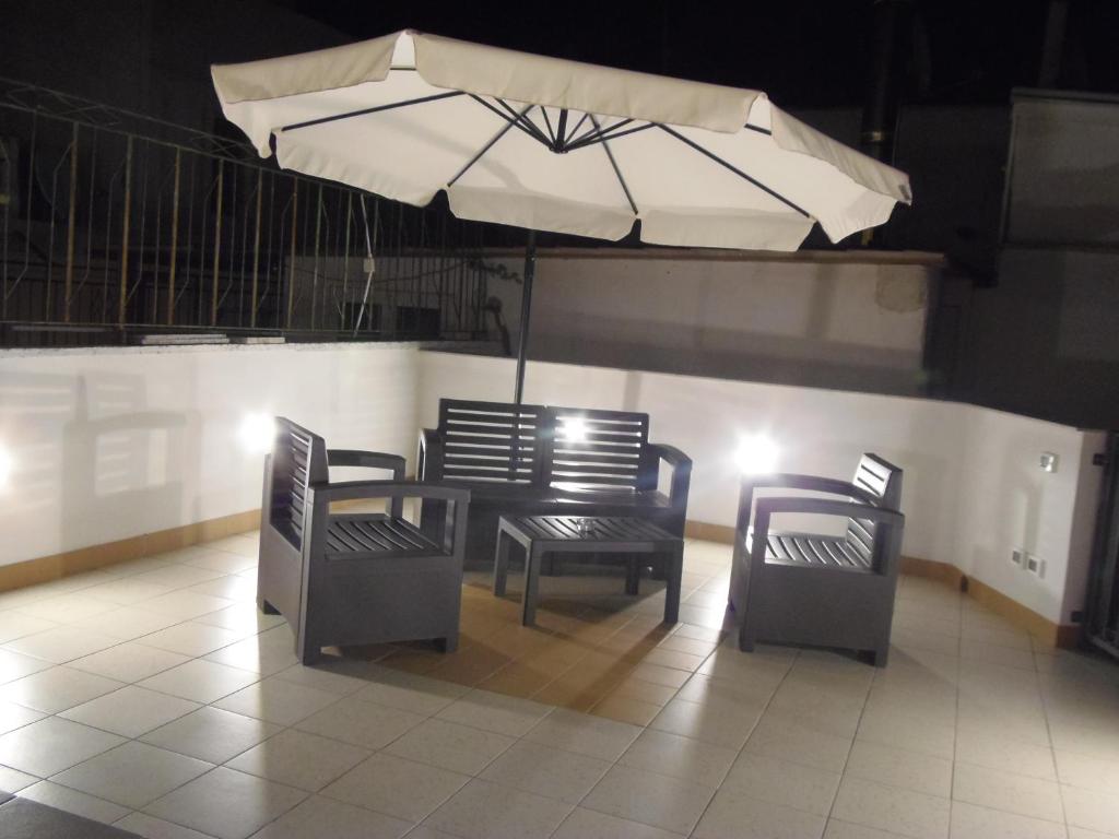een tafel en twee stoelen met een paraplu bij B&B LuiRò in Castellaneta