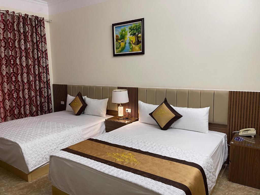 ein Hotelzimmer mit 2 Betten und einem Telefon in der Unterkunft Phước Thịnh Hostel - Ngõ 19 P. Nguyễn Văn Lộc, Hà Đông - by Bay Luxury in Hanoi