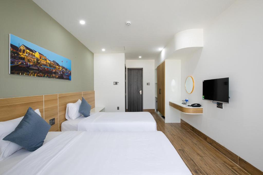 Rúm í herbergi á FIRST Studio Hotel Da Nang