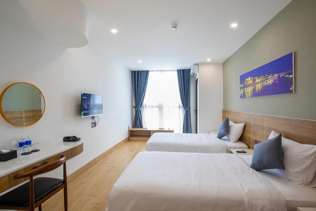 Rúm í herbergi á FIRST Studio Hotel Da Nang