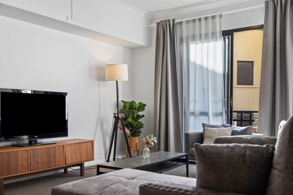 a living room with a television and a couch at Family Apartment close to Perth City in Perth
