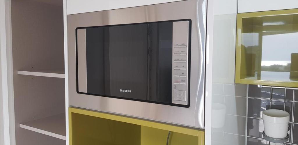 a kitchen with a microwave oven in a kitchen at Joongmoon ocean stay in Seogwipo