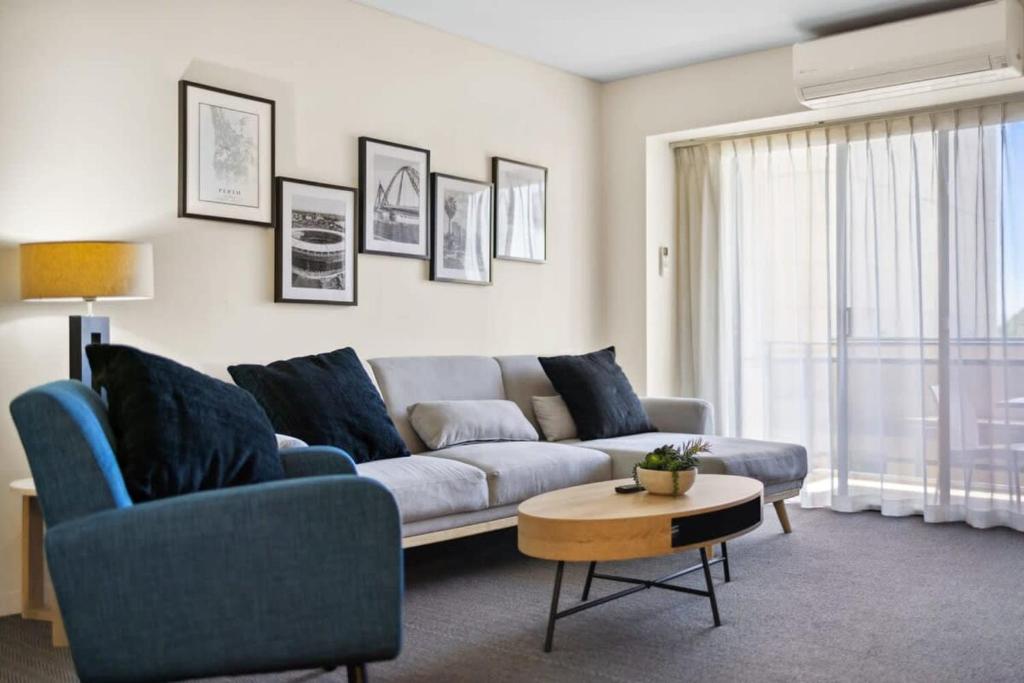 - un salon avec un canapé et une table dans l'établissement Spacious Holiday Apart on Hay St CBD, à Perth