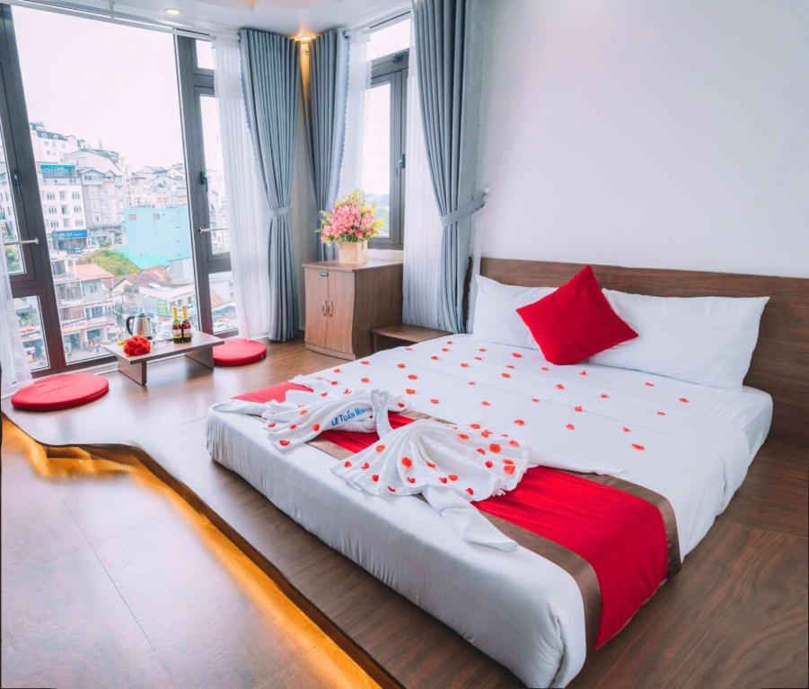 a bedroom with a large bed with red and white sheets at Le Tuan Minh Hotel in Da Lat