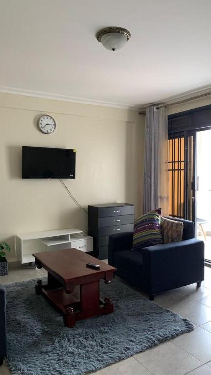 - un salon avec un canapé et une table basse dans l'établissement Haz Furnished Apartments Buwate, à Kampala