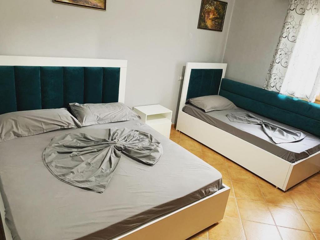 a bedroom with two beds and a couch at Ilirian Hotel in Lezhë