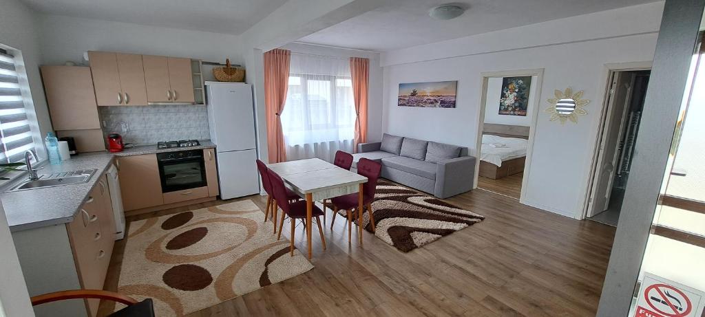 eine Küche und ein Wohnzimmer mit einem Tisch und einem Sofa in der Unterkunft Apartament Sânpetru-Brașov in Sînpetru
