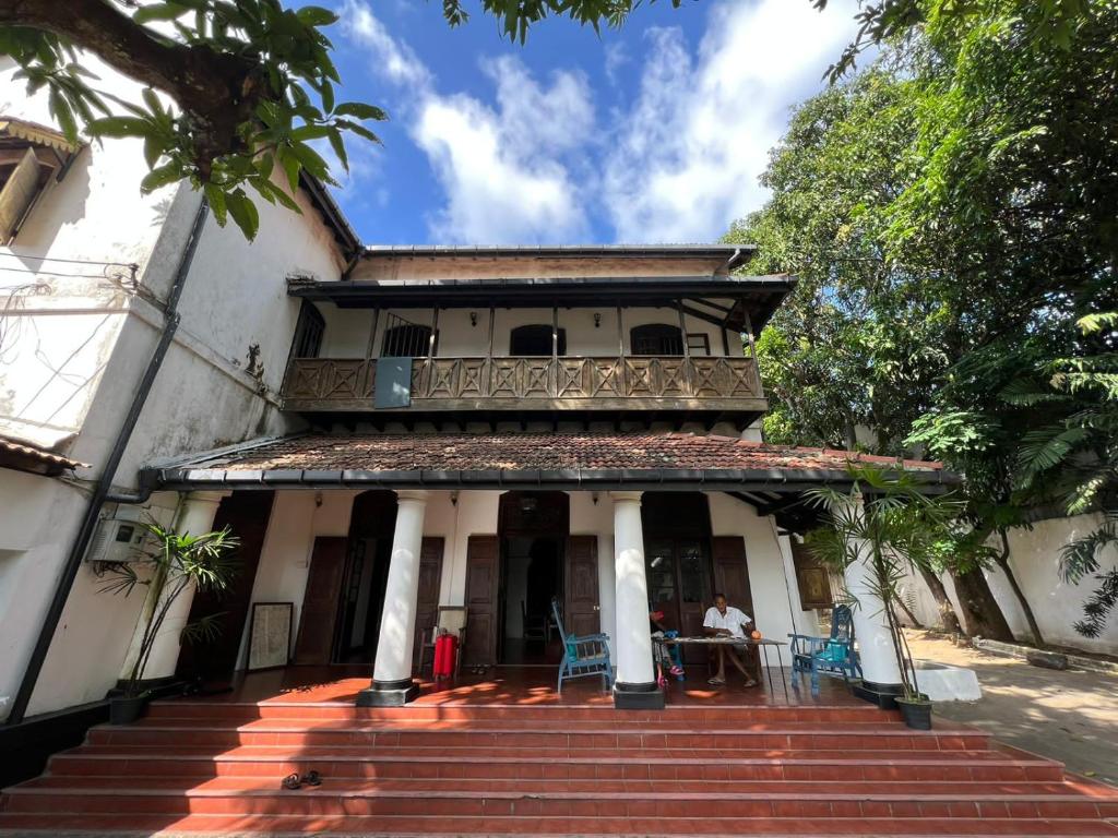 a man sitting at a table in front of a house at College House Close to Fort in Colombo