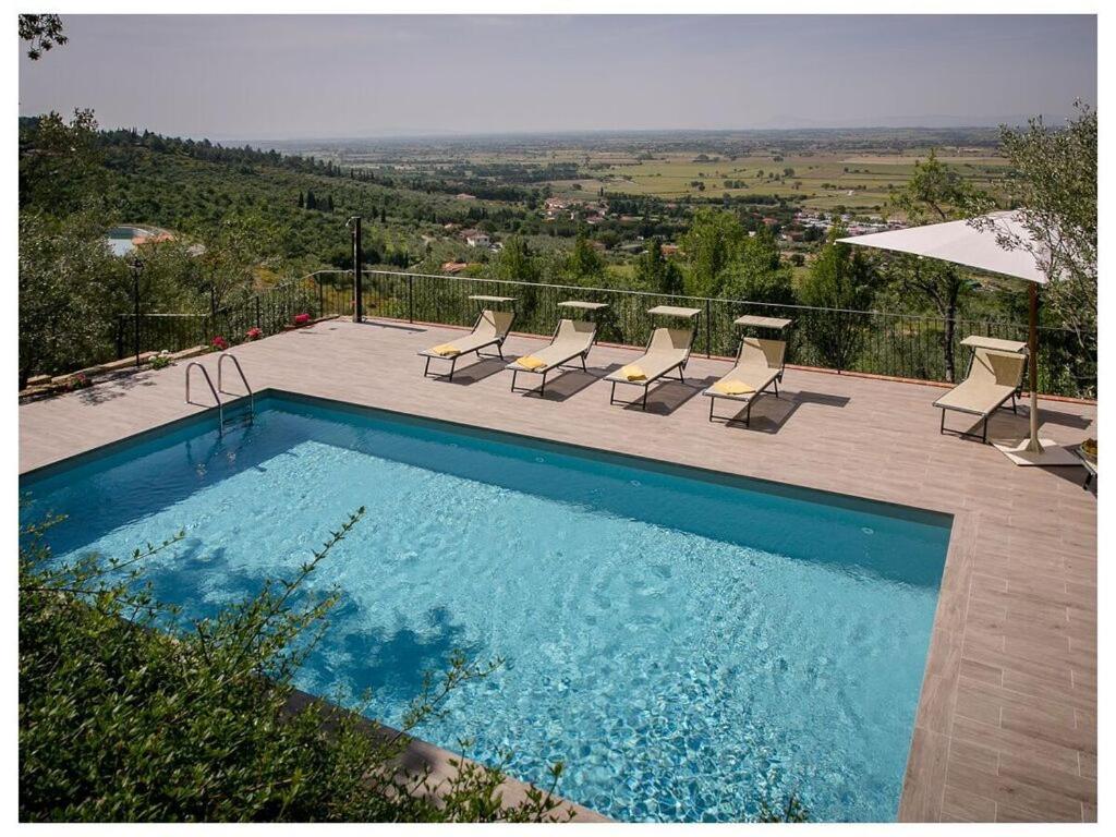 una piscina con sillas y vistas a una colina en Villa Montecchio, en Cortona