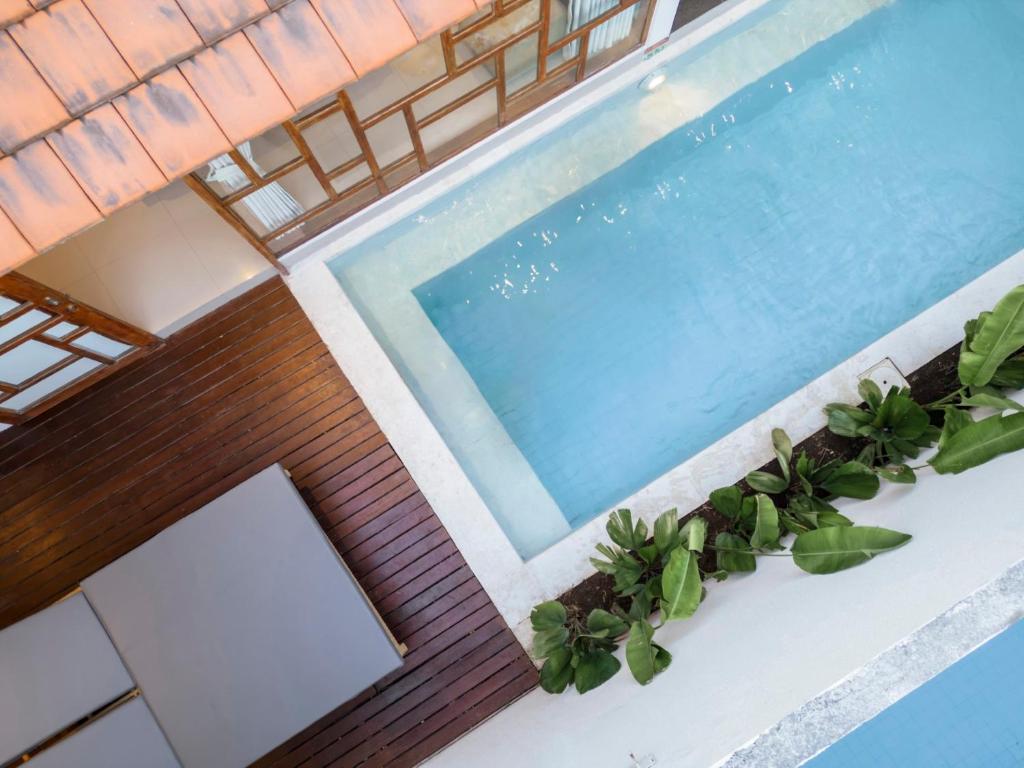 a swimming pool in a house with plants at Manca Villa Canggu by Ini Vie Hospitality in Canggu