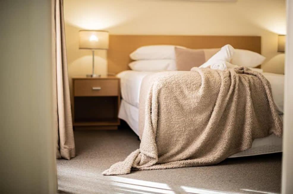 a hotel room with a bed with a blanket on it at Exceptional Apt in the heart of Perth City in Perth