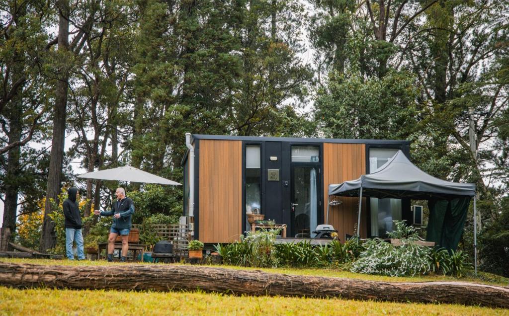 a tiny house with people standing in front of it at Binderaga Old Orchard in Bilpin