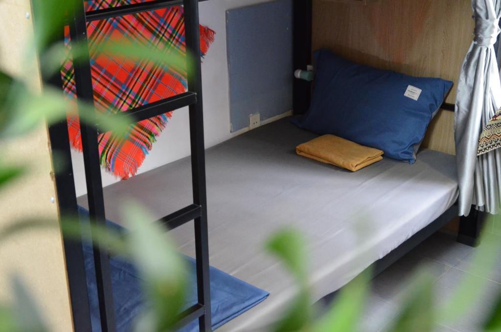 una piccola stanza con un letto a castello con un cuscino blu di Northern hostel 2 - Bui Vien Walking Street ad Ho Chi Minh