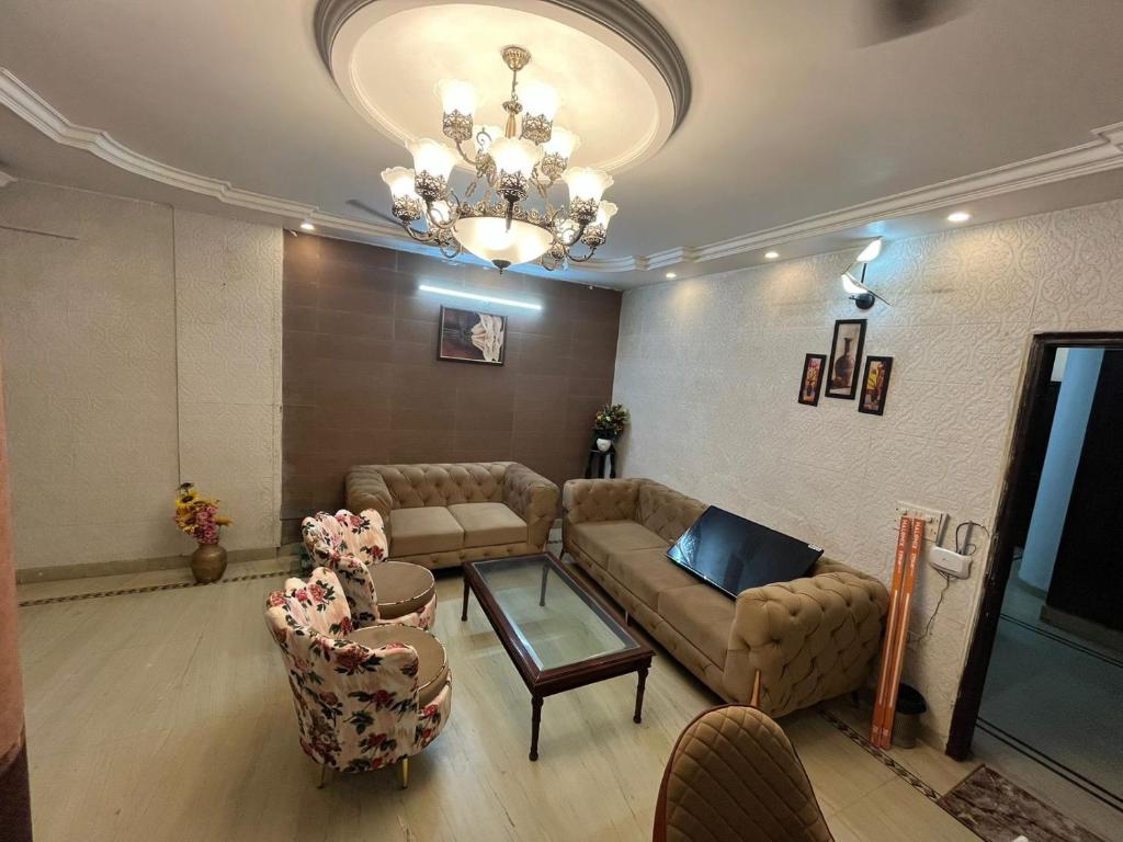 a living room with a couch and chairs and a chandelier at Divine India Service Apartment 3 BHK D-198 Saket in New Delhi