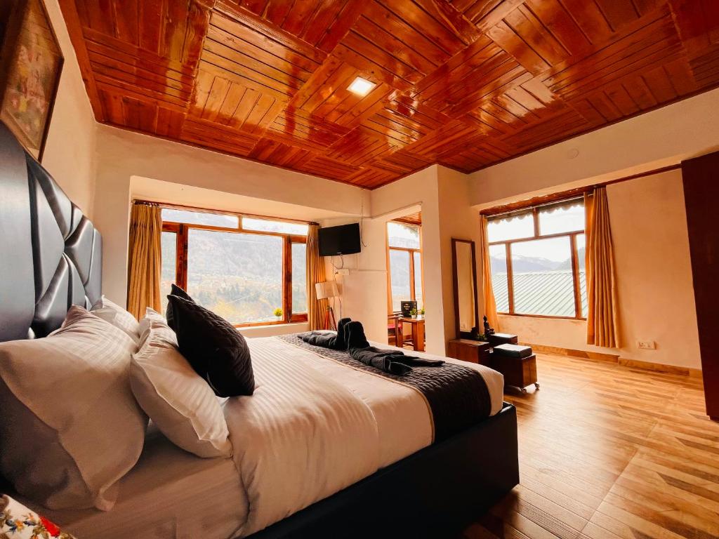 a bedroom with a large bed with a wooden ceiling at Varsha Guest House in Vapi