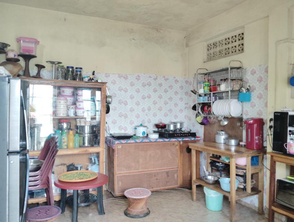 a kitchen with a refrigerator and a table and chairs at Aqhe Homestay in Kohīma