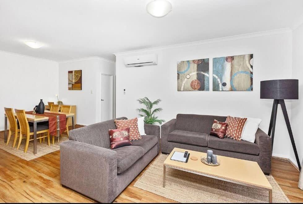 パースにあるExecutive Apt - 2BR 1BA w Parkingのソファ2つとテーブルのあるリビングルーム