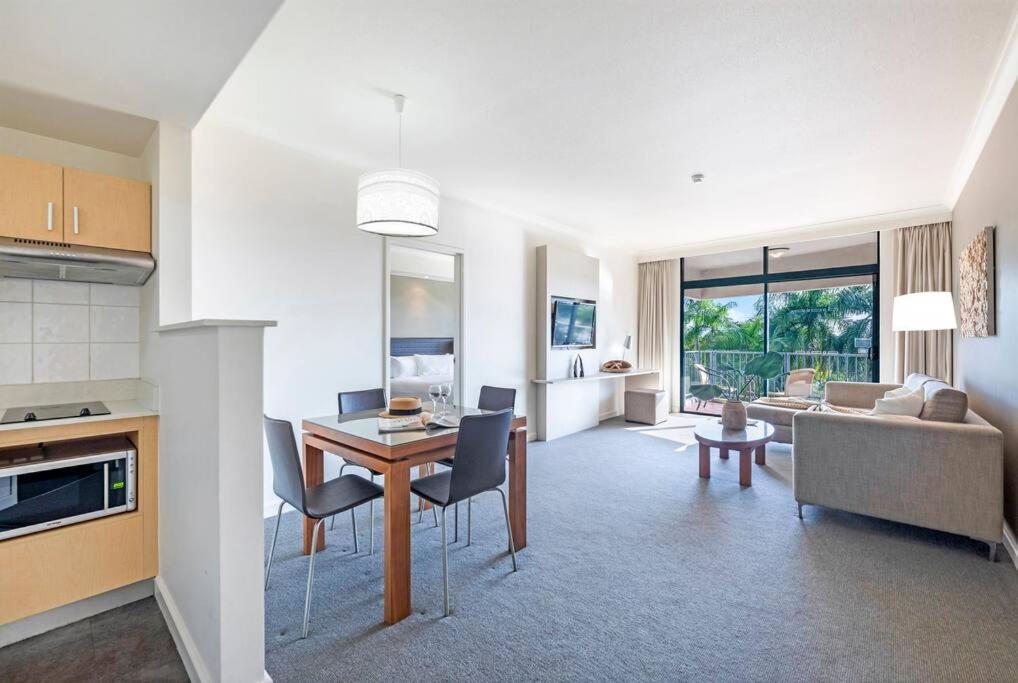 a kitchen and living room with a table and chairs at Idyllic Waterfront Pool Escape with Esplanade View in Darwin