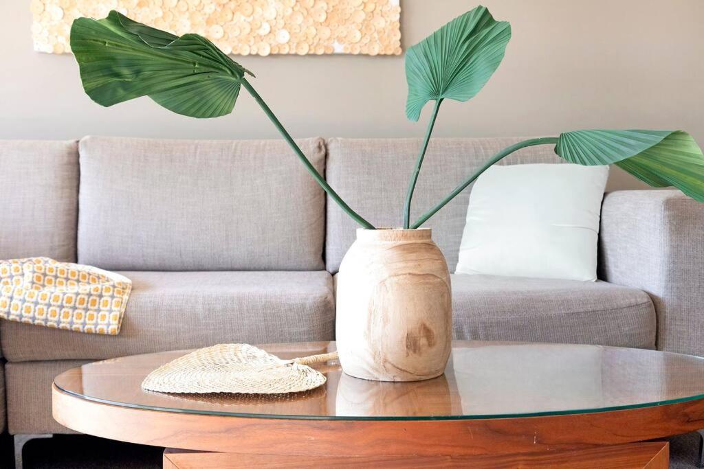 a living room with a table with a plant on it at Idyllic Waterfront Pool Escape with Esplanade View in Darwin