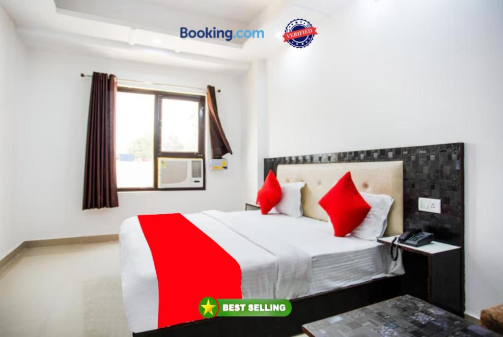 um quarto de hotel com uma cama com almofadas vermelhas em Hotel Raj Ganga Haridwar Near Raja Ji National park Jeep Safari - Excellent Customer Choice- Best Seller em Haridwar