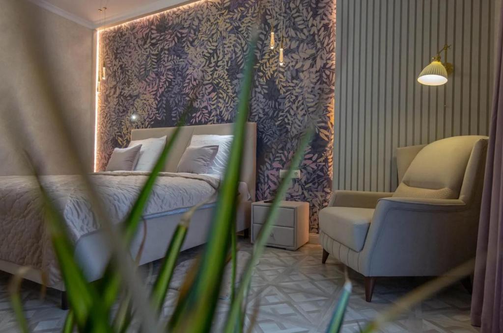 um quarto com uma cama, uma cadeira e um espelho em Modern Entire Apartments em Colombes