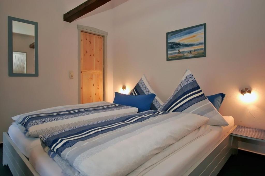 een slaapkamer met een bed met blauwe en witte lakens bij FeWo Erle - Ulenhoef in Prerow