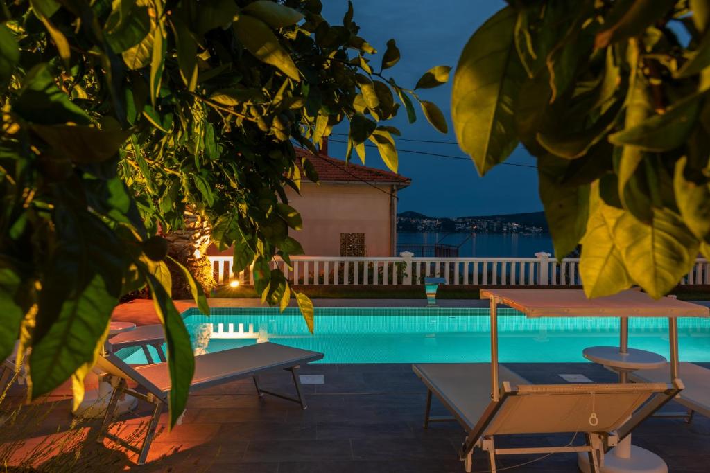 - une piscine avec 2 chaises et une maison dans l'établissement Villa Ana Trogir II, à Trogir