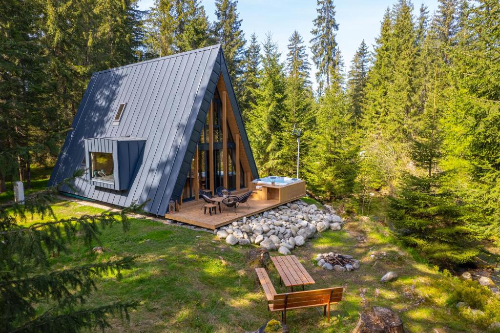 eine Hütte im Wald mit einer Terrasse und einer Bank in der Unterkunft Chata Idylka in Pribylina