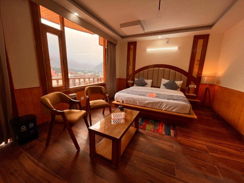 1 dormitorio con cama, mesa y ventana en Sawdesh hotel en Vapi