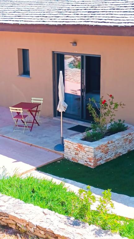 une maison avec une table et une terrasse dans l'établissement Agréable chambre dans le maquis, à Bonifacio