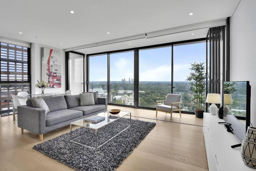 uma sala de estar com um sofá e uma mesa em Amazing two bedroom St Leonards ATC62010 em Sidney