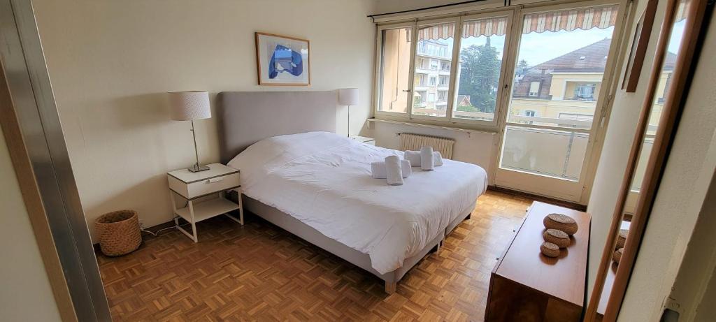 een slaapkamer met een wit bed en een raam bij 321 Perfectly situated in Ouchy near IMD in Lausanne