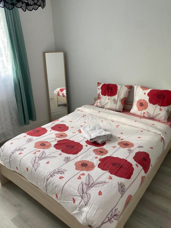 une chambre avec un lit avec des fleurs rouges dessus dans l'établissement Appartement entier, à Montpellier