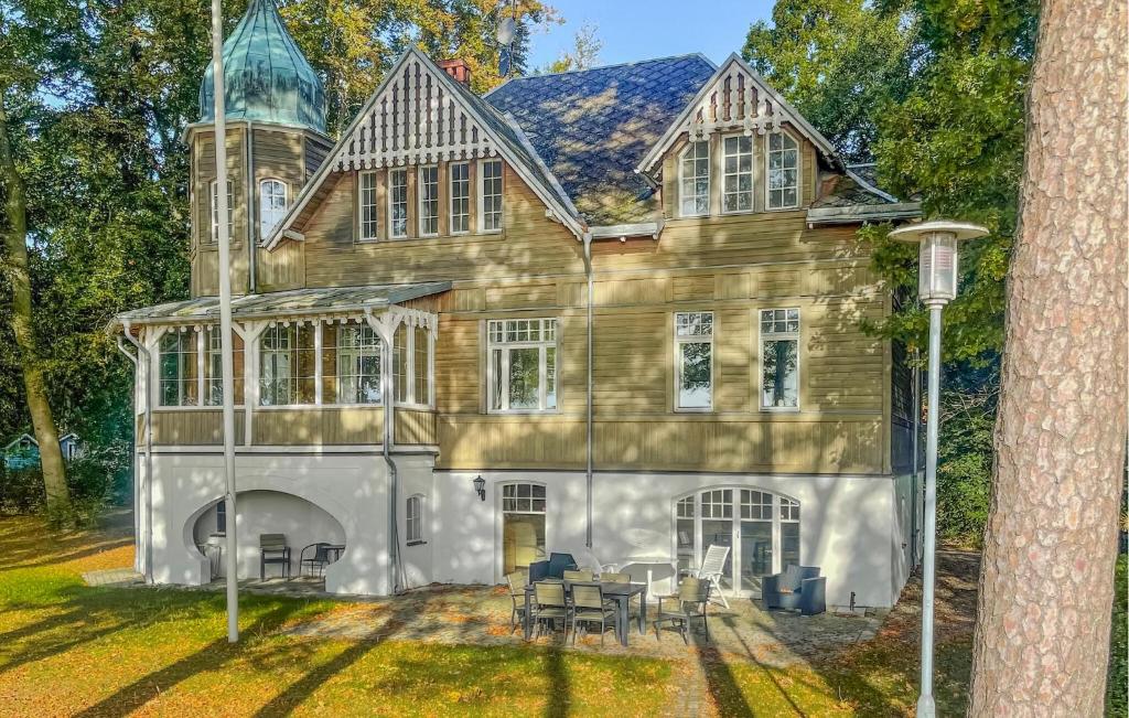 Cette grande maison en bois comprend une table et des chaises. dans l'établissement Villa Sommarro, à Ystad