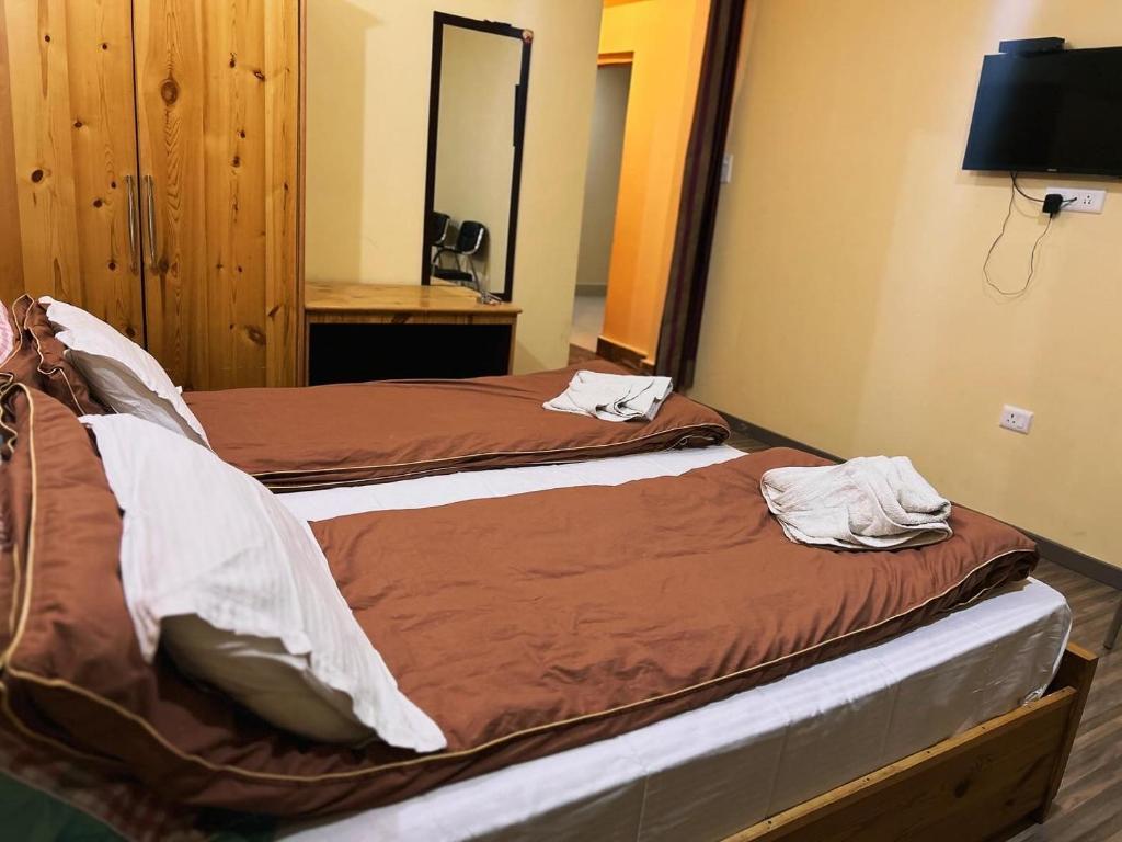 two twin beds in a room with a mirror at The Puma house in Leh