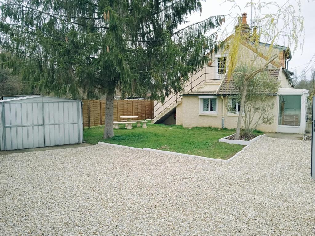 een achtertuin met een huis en een wit hek bij Gîte de Montapeine in Breteau